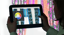 A user changes the color of drapes on a tablet using a mobile Augmented Reality application.